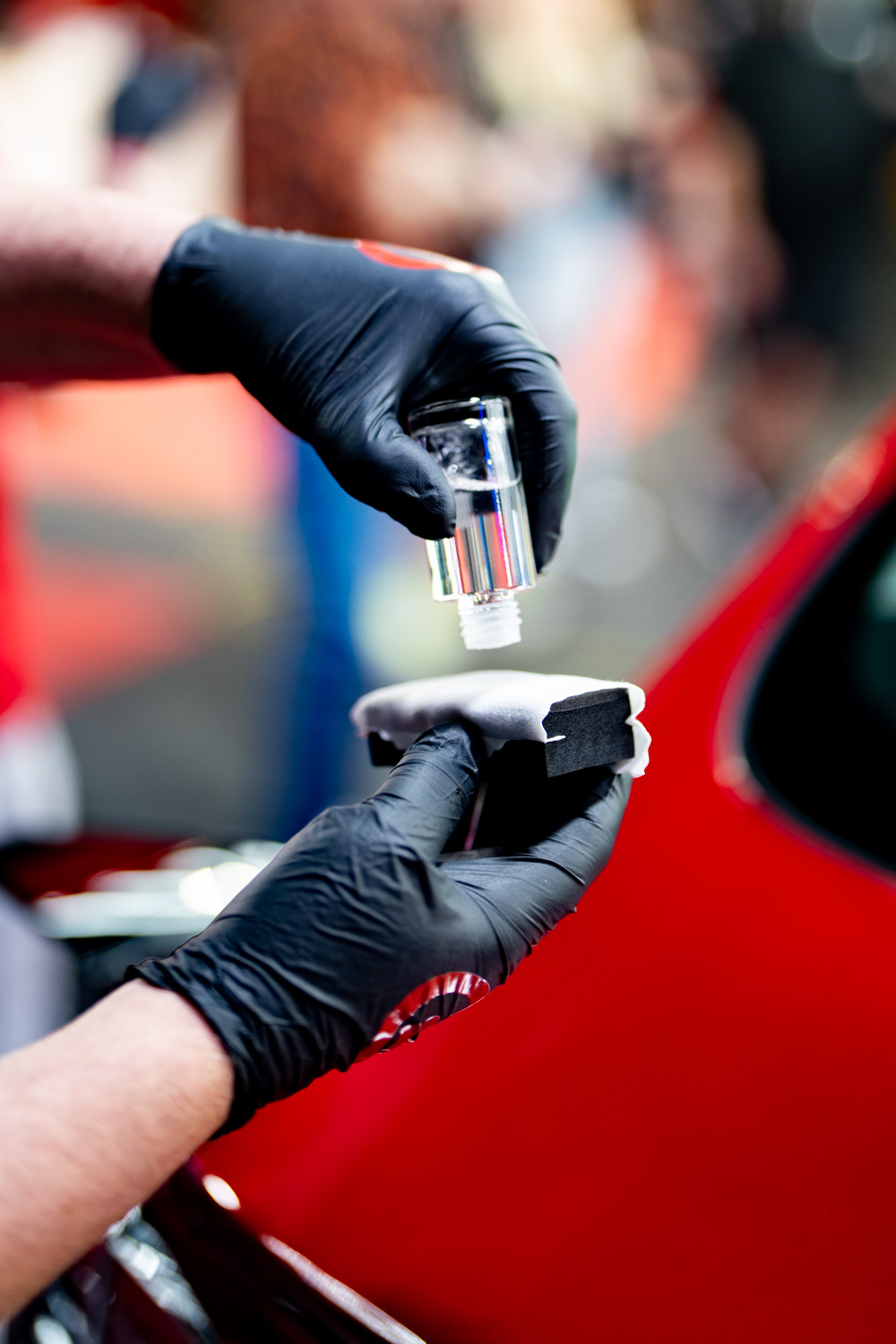 an Installer prepares to coat a car by spreading Fireball Ceramic Coating on a Fireball Applicator suede